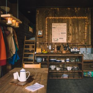 Un chalet en bois chaleureux avec une cuisine rustique, éclairé par des guirlandes lumineuses.