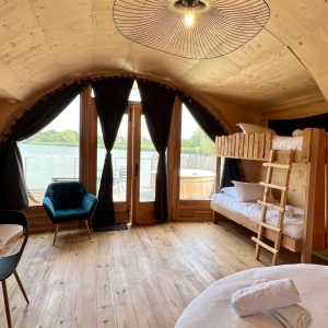 Cabane en bois avec vue sur l'eau, lit superposé et ambiance chaleureuse.