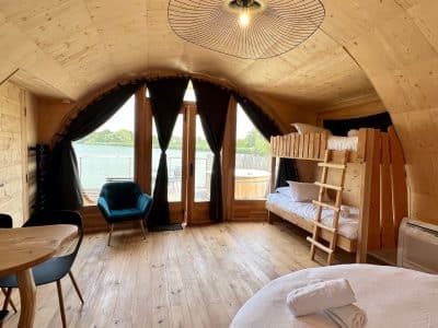 Cabane en bois avec vue sur l'eau, lit superposé et ambiance chaleureuse.