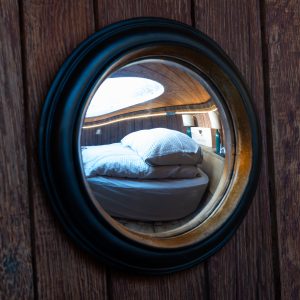 Reflet d'une chambre cosy dans un hébergement insolite en bois, ambiance chaleureuse.