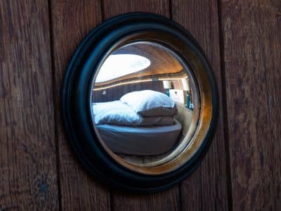 Reflet d'une chambre cosy dans un hébergement insolite en bois, ambiance chaleureuse.