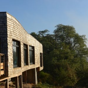 Cabane en bois sur pilotis, avec vue dégagée sur la nature environnante.