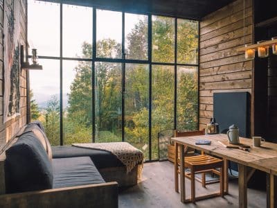 Cabane moderne avec grandes fenêtres, offrant une vue imprenable sur la nature environnante.