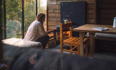 Cabane en bois avec poêle à bois, ambiance chaleureuse et vue sur la nature.
