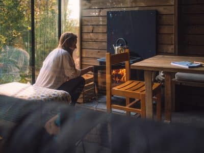 Cabane en bois avec poêle à bois, ambiance chaleureuse et vue sur la nature.