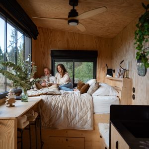 Cabane moderne en bois, avec grandes fenêtres et décoration chaleureuse, idéale pour un séjour