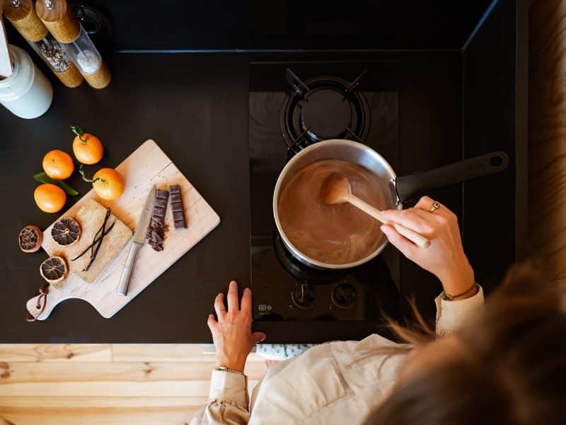 Cuisine moderne dans un chalet, avec chocolat chaud et fruits frais sur le plan de travail.