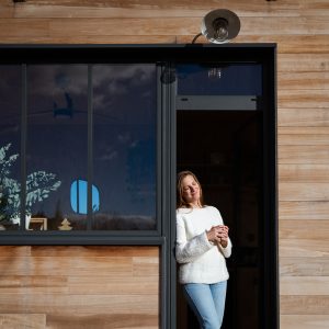Hébergement insolite : chalet en bois avec grandes fenêtres, ambiance chaleureuse et moderne.