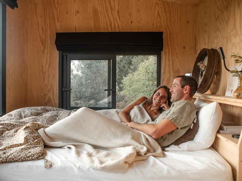 Chalet en bois avec vue, couple détendu sur un lit confortable.
