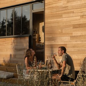Un chalet en bois moderne, avec une terrasse accueillante, parfait pour un moment convivial.