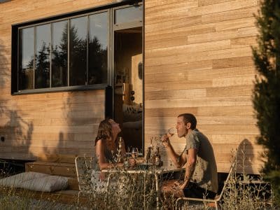 Un chalet en bois moderne, avec une terrasse accueillante, parfait pour un moment convivial.