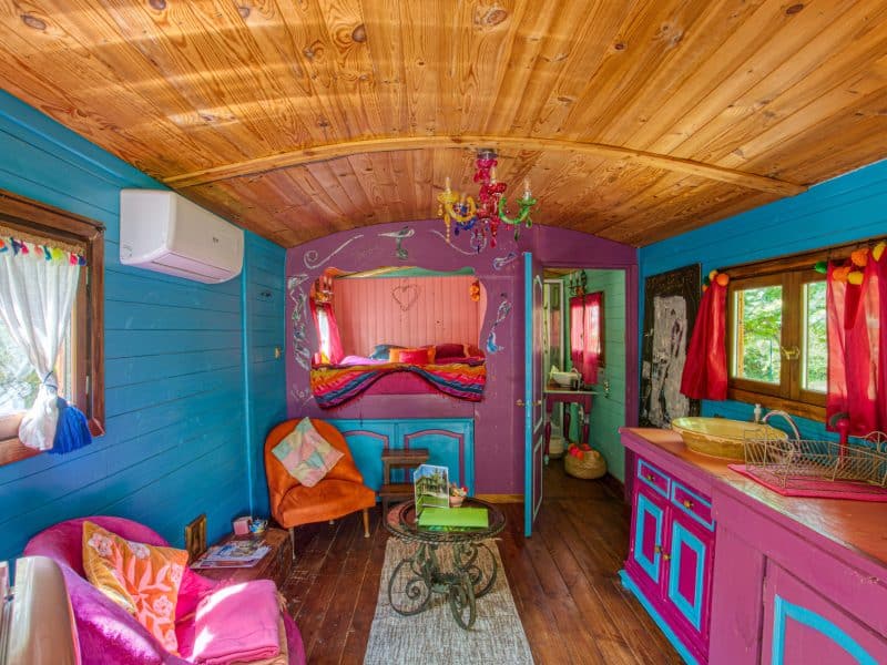 Charmante cabane colorée avec un intérieur en bois et des touches décoratives vives.