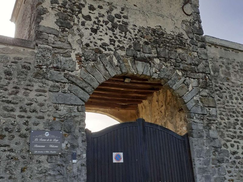 Ancien château en pierre avec une grande porte en bois, offrant un charme historique.