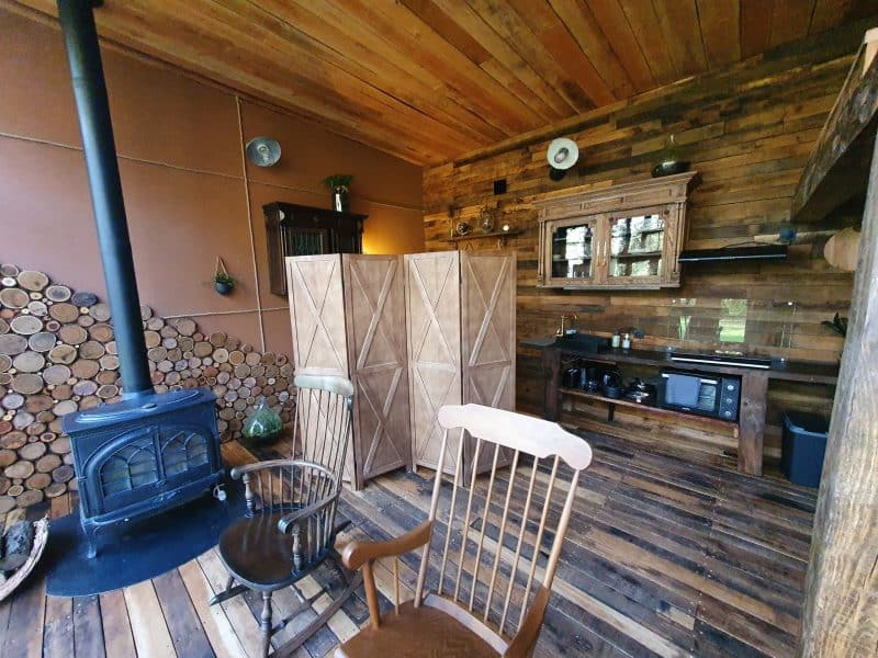 Cabane en bois avec un poêle à bois et un intérieur chaleureux en bois.