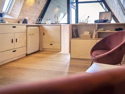 Hébergement insolite en Bourgogne : intérieur moderne avec cuisine et fauteuil design.