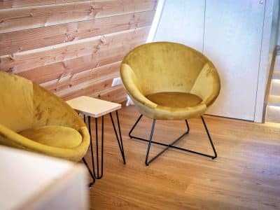 Hébergement insolite en Bourgogne avec fauteuils jaunes et ambiance chaleureuse en bois.