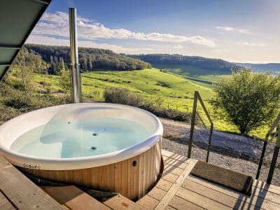 Hébergement insolite en Bourgogne avec jacuzzi extérieur et vue sur la campagne verdoyante.