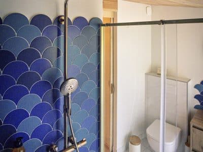 Douche moderne dans un hébergement insolite en Bourgogne, avec carrelage bleu.