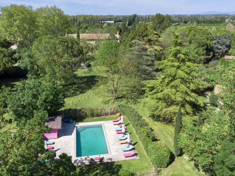 Villa avec piscine entourée de verdure luxuriante et dun jardin spacieux.