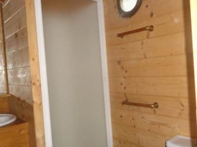 Cabane en bois en Bretagne, avec un lavabo et des murs en bois chaleureux.