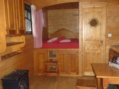 Roulotte en bois cosy en Bretagne, avec lit douillet et cuisine équipée.