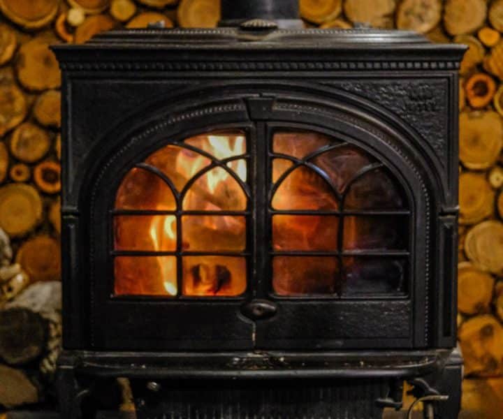 Chalet chaleureux avec un poêle à bois et des chaussures près du feu.