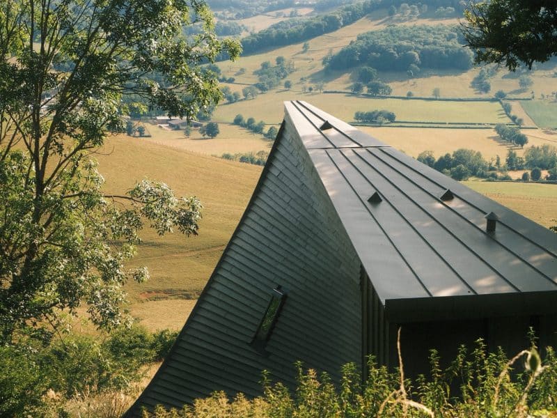 Hébergement insolite en Bourgogne : cabane moderne avec toit en pente, vue sur les collines.