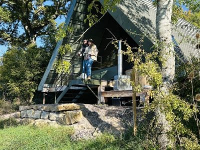Cabane atypique en Bourgogne, avec un toit en pente et une terrasse en bois.