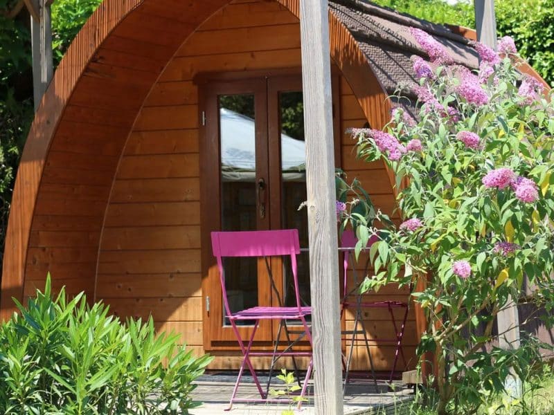 Cabane en bois à Provence-Alpes-Côte dAzur, avec chaises roses et fleurs colorées.
