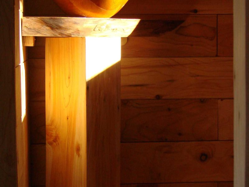 Hébergement en bois avec un lavabo en bois sculpté, lumière naturelle douce.