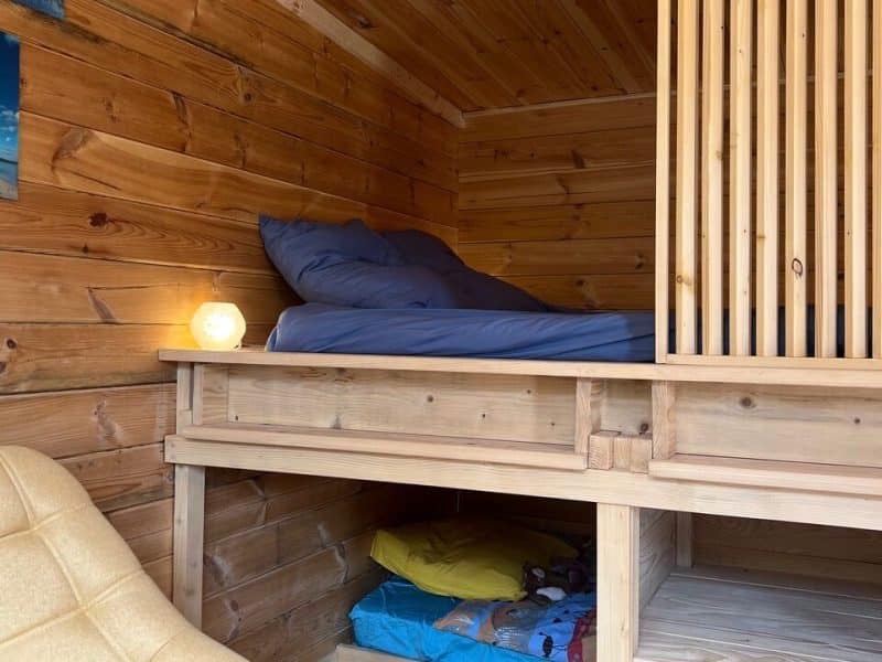 Chalet en bois chaleureux avec lit confortable et coin détente.