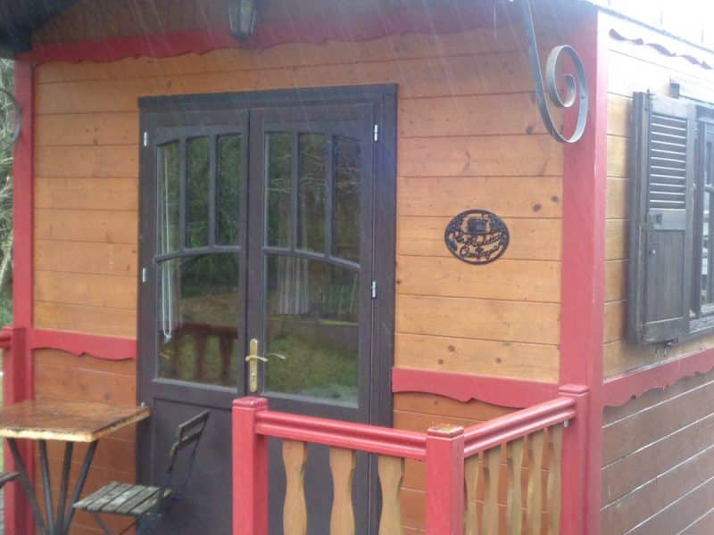 Cabane en bois en Bretagne, avec balcon et fenêtres à volets.