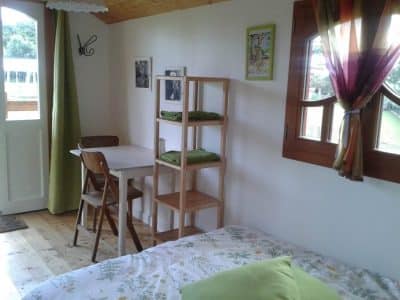 Hébergement insolite en Bretagne : chambre cosy avec table en bois et vue sur la nature.
