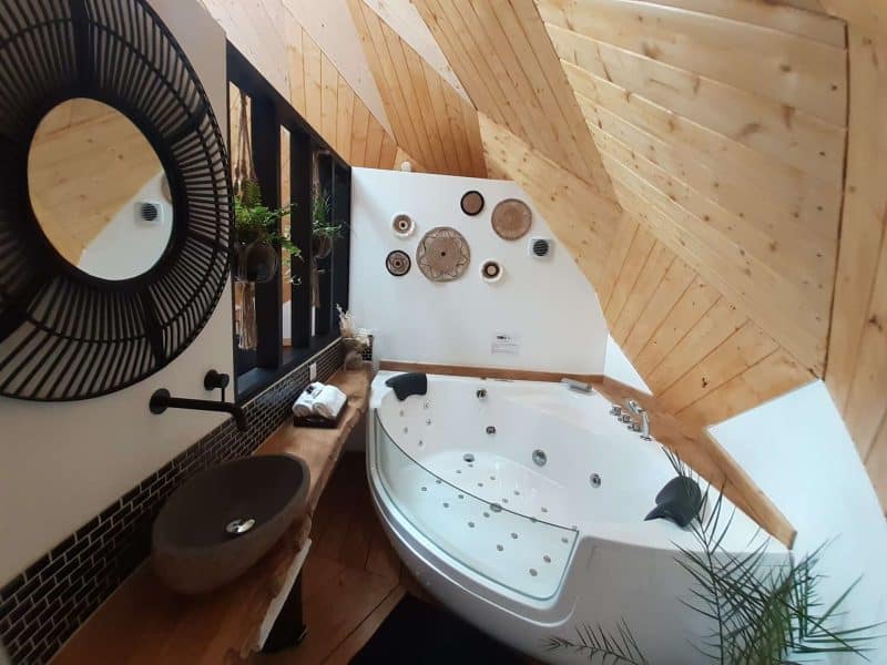 Chalet avec salle de bains moderne, baignoire balnéo et bois chaleureux.