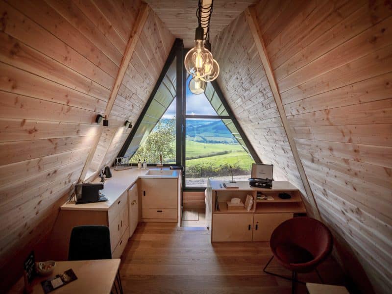 Chalet moderne en bois avec vue panoramique sur la vallée verdoyante.