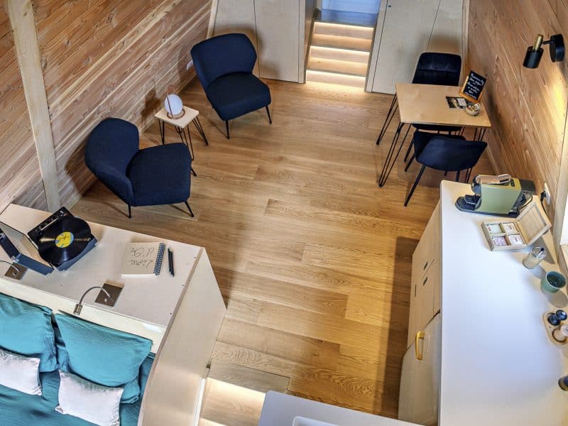 Chalet moderne en bois, avec un coin salon cosy et des touches de décoration élégantes.