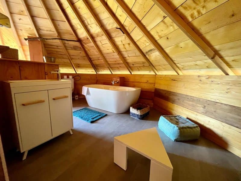 Hébergement insolite en Midi-Pyrénées : chalet en bois avec baignoire moderne.
