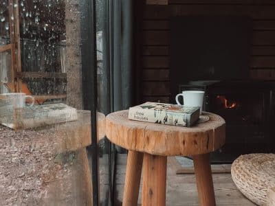 Hébergement insolite en Wallonie : chalet en bois avec vue sur la nature et feu de cheminée.