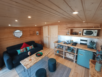 Cabane en bois cosy avec salon lumineux et décoration colorée.