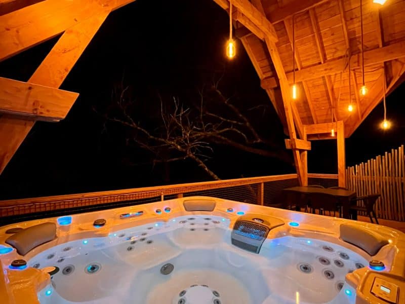 Chalet avec jacuzzi lumineux, ambiance chaleureuse sous un toit en bois.