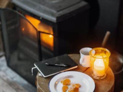 Hébergement insolite en Alsace : un coin chaleureux avec poêle, bougie et petit-déjeuner.