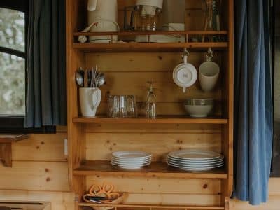 Cuisine en bois dun hébergement insolite en Midi-Pyrénées, avec vaisselle et ustensiles.