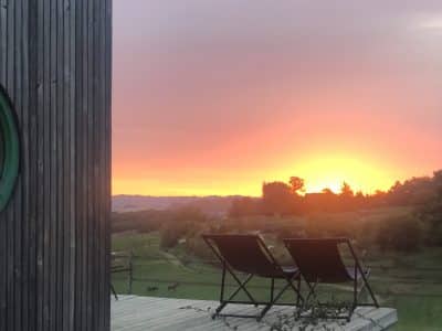 Hébergement insolite en Midi-Pyrénées, avec terrasse et vue sur un coucher de soleil.