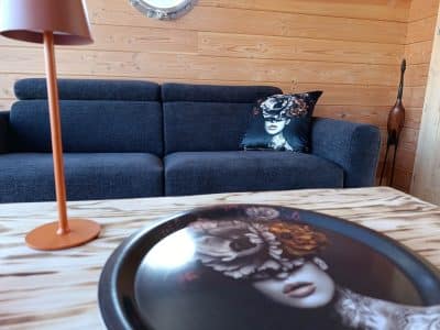 Hébergement insolite en Pays de la Loire : intérieur en bois avec canapé moderne et coussin