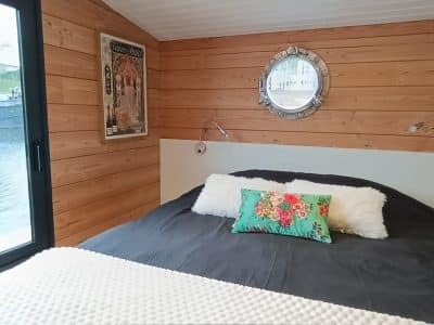 Hébergement insolite en Pays de la Loire : chambre cosy avec mur en bois et décoration colorée.