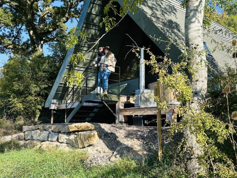 Chalet moderne en bois avec terrasse, entouré de verdure et de nature.
