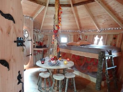 Cabane en bois chaleureuse avec lit douillet et décoration automnale.