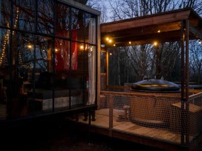 Hébergement insolite en Alsace : cabane moderne avec terrasse et jacuzzi sous les étoiles.