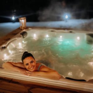 Hébergement de luxe avec jacuzzi illuminé, ambiance relaxante en soirée.