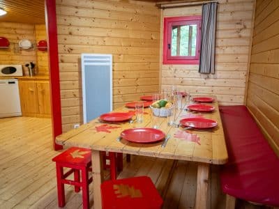 Cabane en bois en Nouvelle-Aquitaine, avec une table en bois et des assiettes rouges.